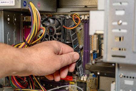 Technician installing a RAM bank into a computer.の写真素材