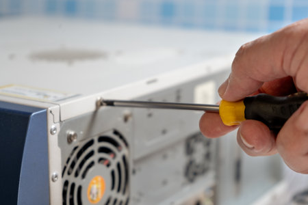 PC technician adjusting the screw on a cabinet lid.の写真素材