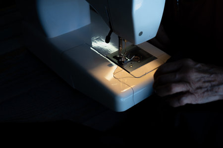 Seamstress threading the sewing machine needle before starting.