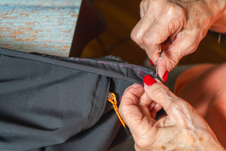 A Hands of a female seamstress manually correcting work on clothing.の写真素材