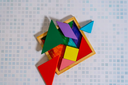A Colorful Tangram puzzle with its messy container.の写真素材