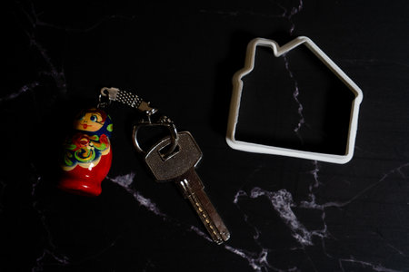 Miniature house profile next to keys on a keychain.の写真素材