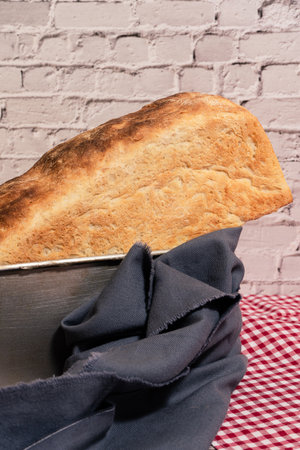 Piece of white bread on a cutting board with a knife.