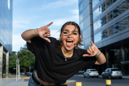 Energetic woman making playful gestures in a city environmentの写真素材