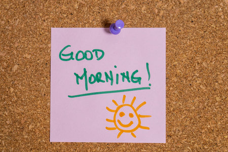 Pink sticky note wishing good morning on cork boardの写真素材