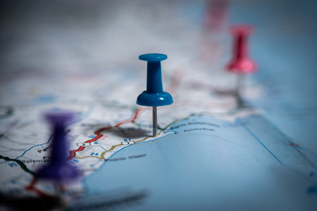 Blue push pin marking location on road map with other pins