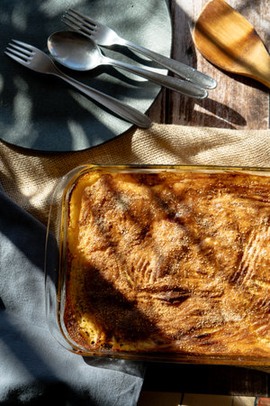 A Glass platter with a meat or shepherd's pie on a rustic country table.の写真素材