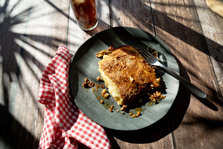 A slice of homemade potato pie served on a plate on a rustic tableの写真素材