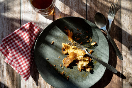 A dirty plate with the remains of a slice of shepherd's pie or meat pie after eating.の写真素材