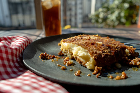 A slice of homemade shephard's pie served on a plate on a rustic table