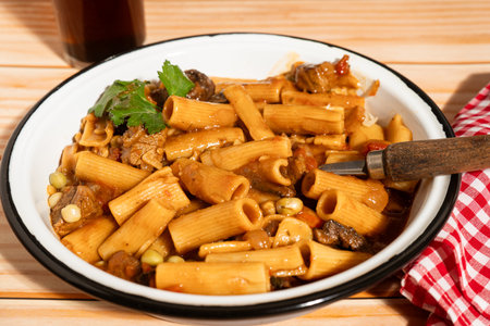 Parsley garnish adds freshness to this hearty bowl of beef, vegetable, and rigatoni pasta, ready for...