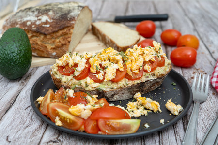 Rustic bread topped with tomatoes and scrambled eggsの写真素材