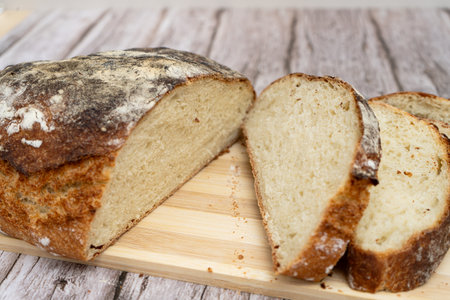 Freshly baked rustic bread sliced on a wooden board
