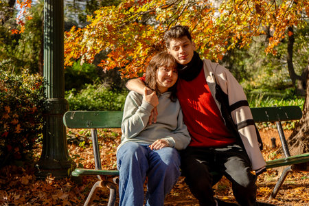 Teenagers enjoying a romantic moment together in a vibrant autumnal park settingの写真素材