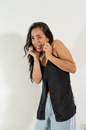 Studio portrait of a young woman experiencing a panic attack, expressing fear and anxietyの写真素材