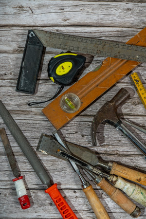 Set of vintage woodworking tools on a weathered wooden workbench, creating a still life of traditional craftsmanshipの写真素材