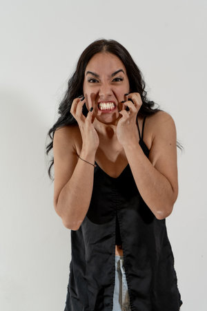 Young woman is feeling angry and frustrated, showing teeth and nailsの写真素材