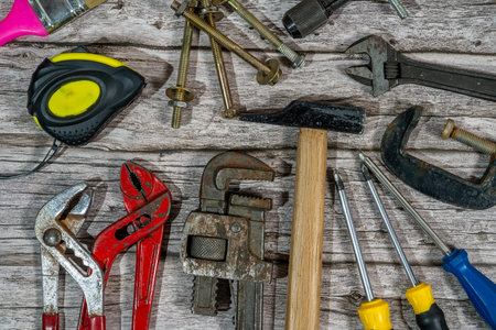 Various handyman tools are laying on a wooden background, ready for home improvement and diy projectsの写真素材