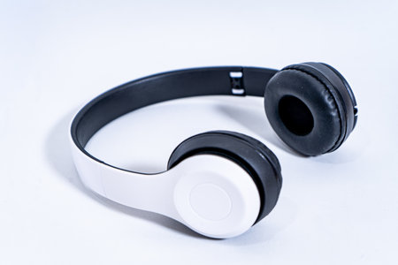 Modern wireless headphones resting on white surface
