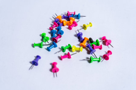 Vibrant pushpins creating a colorful display on a clean white background, perfect for representing office supplies, school projects, or creative endeavorsの写真素材