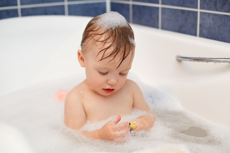 Baby in the bathroom with foam bathの写真素材