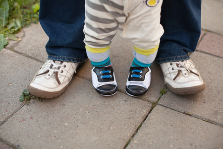 Legs of father and son, making first steps. Top viewの写真素材