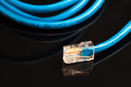 Blue computer ethernet cable isolated on black background, closeup