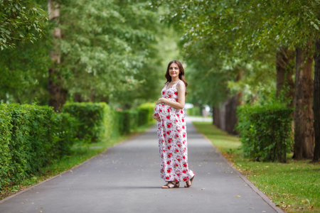 Young pregnant woman touching her belly with handsの写真素材