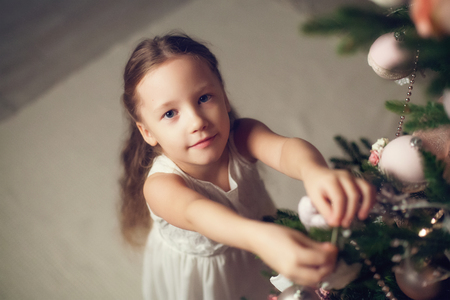 Little girl decorating christmas tree, top view, vintage tonedの写真素材