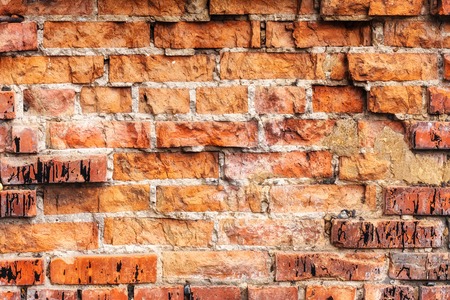 Weathered stained old orange and red brick wall, texture grunge backgroundの写真素材
