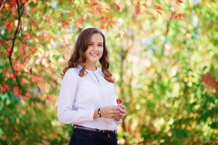 Young cheerful beautiful woman. Beauty smiling teenager girl in autumn parkの写真素材