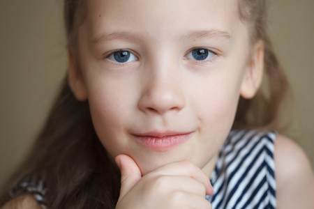 Face portrait of little cute happy girl, smiling and posing, closeupの写真素材