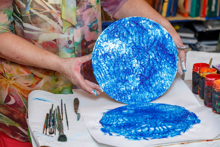 Abstract acrylic intuitive painting process. Woman artist drawing picture on round canvasの写真素材