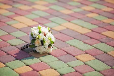 Beautiful bridal wedding bouquet on colorful paving stonesの写真素材