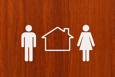 Paper man, woman and house on wooden background. Housing, family concept. Abstract conceptual imageの写真素材