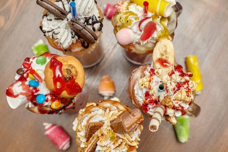 Group of caramel marshmallow candy milk shake cocktails with whipped cream, cookies, waffles and...