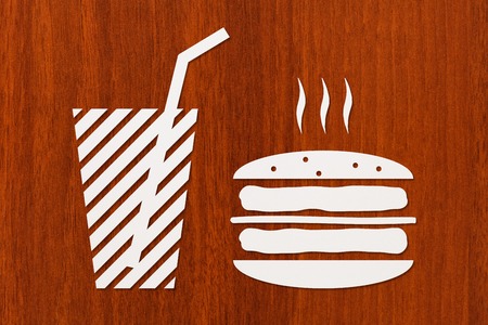 Paper burger and beverage inside on wooden background, fastfood concept. Abstract food conceptual imageの写真素材