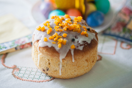 Traditional easter cake kulich Ukrainian Russian style with colored eggs on table