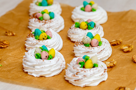Mini Pavlova meringue nest with eggs, easter sweets, closeup