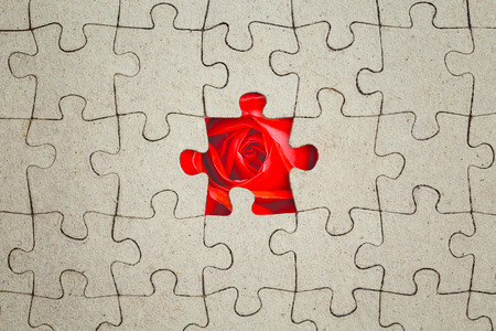 Missing jigsaw puzzle piece and red rose inside. Abstract conceptual imageの写真素材