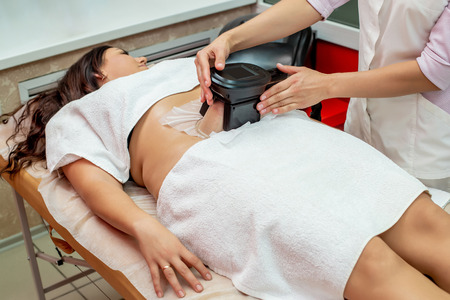 Woman getting cryolipolysis fat treatment procedure in professional cosmetic cabinet or spa centerの写真素材