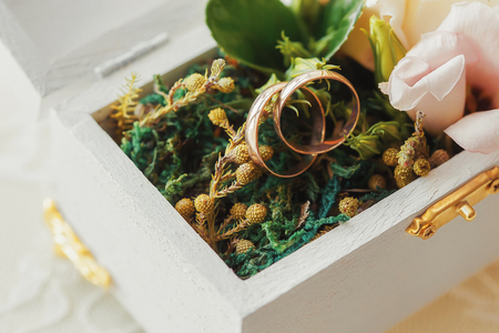 Wedding rings in wooden box closeup, eco style, marriage concept