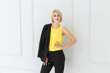 Fashion portrait of woman in yellow and black suit on light backgroundの写真素材