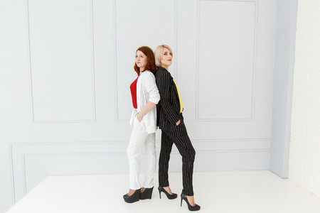 Fashion portrait of women in white and black suit on light backgroundの写真素材