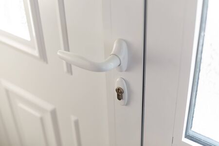 White plastic handle or doorknob and lock of closed house doorの写真素材
