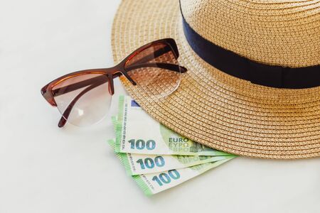 Sun hat with sunglasses and 100 hundredth euro banknotes. Money or vacation conceptの写真素材