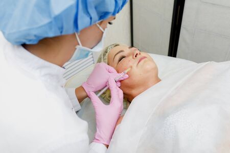 Beautician doing facial injection for woman. Anti-aging revitalization cosmetology procedureの写真素材