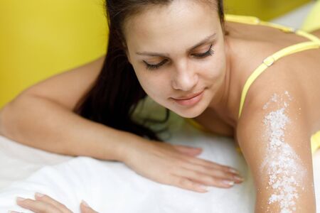 Woman brunette getting salt scrub treatment in beauty or spa salonの写真素材