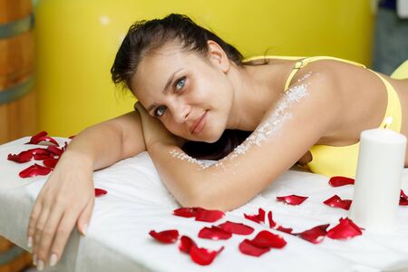 Woman brunette getting salt scrub treatment in beauty or spa salonの写真素材