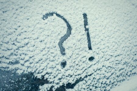 Snow covered car with question and exclamation mark on window, conceptの写真素材